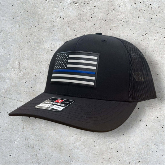 Thin Blue Line Hat featuring a UV-printed American flag patch on a black Richardson 112 trucker cap.