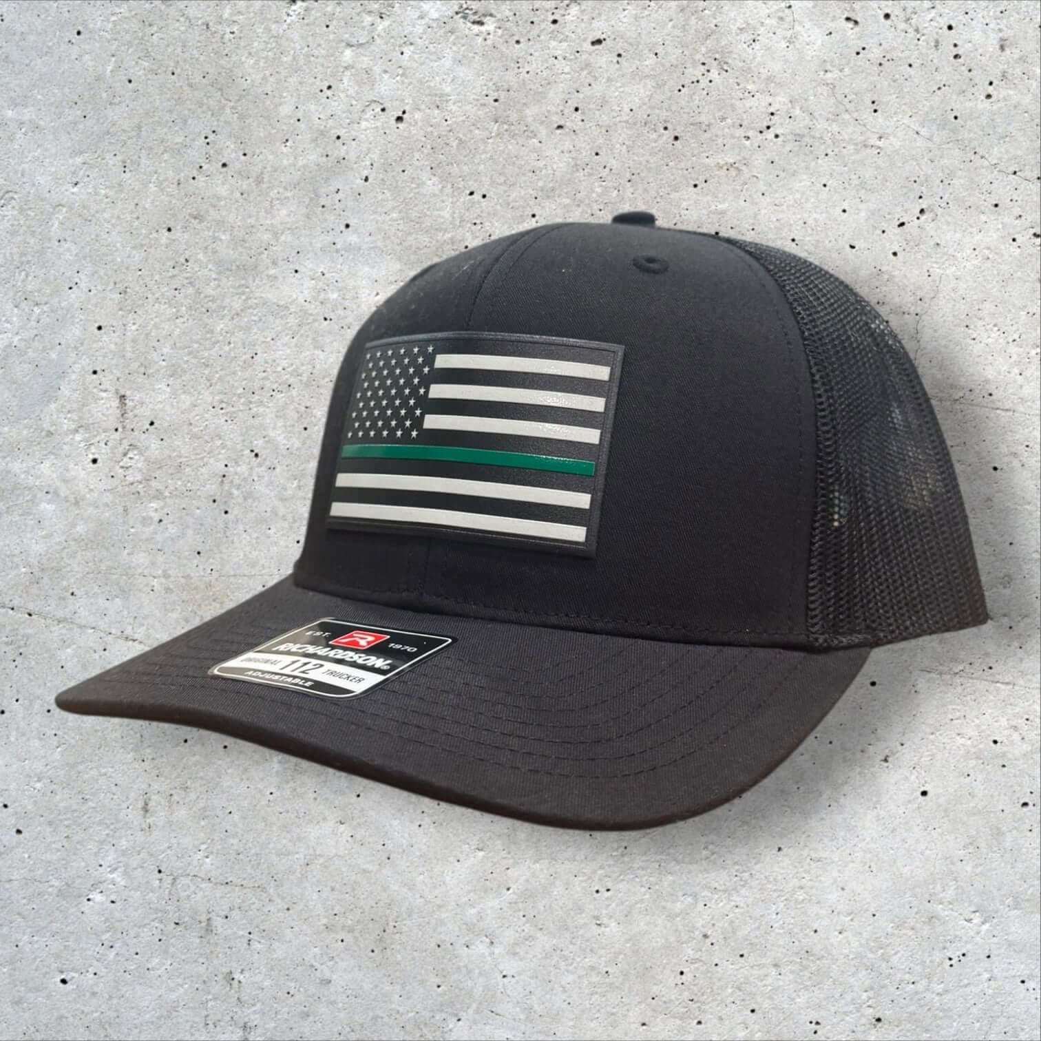 Thin Green Line Hat with textured American flag patch, Richardson 112 trucker style, perfect for military and patriotic support.